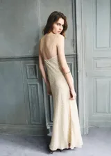 Vestido largo color crudo con sutil textura en relieve, escote drapeado y tirantes finos.
