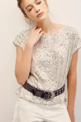 Remera plateada con lentejuelas, de manga corta y cuello redondo.
