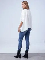 Blusa de crepe color blanco, con corte oversize, cuello redondo y mangas tipo dolman con puños elásticos en punto smock.