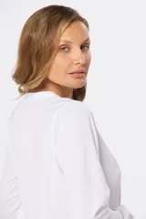 Blusa de manga larga en color azul marino, con escote en V y diseño de doble capa en el frente. Presenta puños elásticos y un pequeño aplique metálico decorativo en el ruedo.
