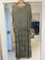 Vestido largo verde agua con diseño en capas de volados con terminaciones deshilachadas, escote redondo y mangas cortas holgadas.