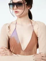 Vestido largo con estampado tie-dye en tonos marrones, naranjas y lilas. Tiene escote halter y espalda descubierta.