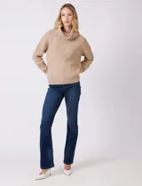 Buzo de punto grueso con textura en relieve, de cuello volcado y mangas largas con hombros caídos. Presenta puños y ruedo con terminación en rib.