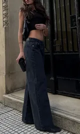 Jeans wide leg de denim rígido, tiro bajo y color negro.