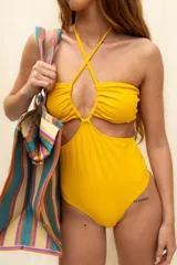 Malla enteriza color amarillo, con diseño cut-out en el abdomen, escote strapless y tiras que se cruzan en el cuello.