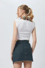 Minifalda de jean negra con corte asimétrico en el frente y deflecado tanto en la cintura como en el ruedo.