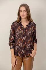 Camisa de manga larga con estampado de leopardo, cuello clásico y cierre frontal de botones. Presenta un corte holgado y puños abotonados.