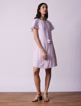 Vestido corto de lino a rayas verticales rosas y blancas, con cuello fruncido, escote en V con lazo de ajuste y mangas cortas con puntilla de crochet.