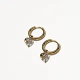 Aros tipo argolla dorados con dije colgante de cristal transparente.