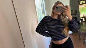 Blusa de manga larga con diseño de hombros caídos, confeccionada en tejido jersey rayado en tonos azul y gris. Presenta un corte ajustado a la cintura y mangas con volumen.