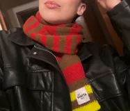 Bufanda tejida a rayas horizontales en tonos marrón, beige y rojo.