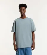 Remera de corte relaxed, confeccionada en algodón de tejido grueso con cuello redondo y mangas cortas.
