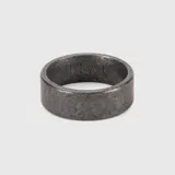 Anillo de diseño tubular con acabado texturizado y efecto envejecido, fabricado en acero.