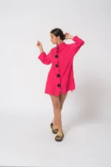 Camisola fucsia con cuello mao, mangas largas con puños y cierre frontal con botones grandes negros.