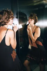 Vestido corto con tirantes finos ajustables, escote en V profundo con paneles en color negro y marrón. Presenta detalles de encaje marrón en el torso y un bajo con volantes de tul negro y encaje festoneado.