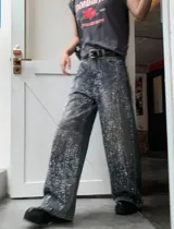 Jean wide leg de tiro alto en denim azul oscuro, con aplicaciones brillantes verticales en toda la prenda. Presenta un calce relajado y oversize.