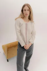 Remera de manga larga color beige, con escote a la base y bordado central en color bordó. La parte delantera es de lino y la espalda de algodón con spandex.