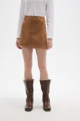 Falda mini de corte recto confeccionada en gamuza sintética color marrón, con cierre frontal de botón y presillas para cinturón.