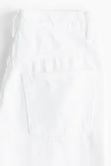 Pantalón de jean blanco de corte ancho, tiro alto y cinco bolsillos. Confeccionado en denim de algodón rígido.