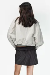 Falda pantalón de tiro medio con estampado de rayas verticales. Presenta un cinturón integrado con hebilla metálica y cierre lateral con cremallera oculta.