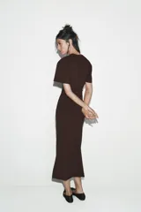 Vestido largo color marrón oscuro, con cuello redondo, manga corta y detalle de drapeado fruncido en el lateral izquierdo, terminando en línea evasé.