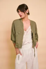 Campera bomber verde militar de lino, con cierre frontal, bolsillos laterales y detalles de cordones ajustables en el ruedo.