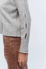 Sweater gris jaspeado de tejido de punto con mangas largas con aberturas.