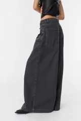 Jean de corte wide leg en color gris oscuro con efecto lavado. Presenta tiro medio, diseño de cinco bolsillos y cierre frontal con botón y cremallera.