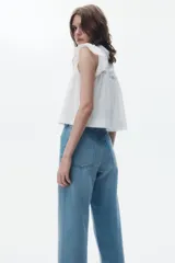 Jean de tiro alto con corte recto y holgado, confeccionado en denim rígido de cinco bolsillos con cierre de botón.