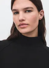 Buzo de cuello perkins y manga larga, con diseño recto y holgado. Confeccionado en tejido suave de modal y poliéster.