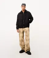 Pantalón de gabardina de algodón Blue Steel, modelo Super Baggy, con diseño amplio y estampa abstracta con efecto manchado en tonos marrón y beige. Cuenta con cintura con presillas, cierre de botón y cremallera, y bolsillos funcionales.