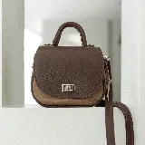 Cartera bandolera de cuero color marrón con asa corta superior y correa larga ajustable.