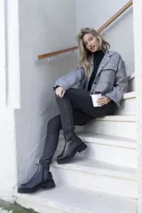 Bota corta de cuero color marrón con suela track negra y cierre lateral con cremallera.