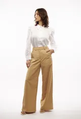 Camisa blanca de lino con cuello clásico, mangas largas con volumen y frunces en los hombros.