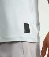 Remera deportiva de hombre en color rojo oscuro, con mangas cortas, cuello redondo y detalle de líneas negras en la manga. Confeccionada en poliéster con tecnología dry fit.