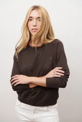 Sweater de punto color marrón, con cuello redondo y manga larga.