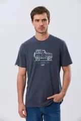 Remera Legacy de manga corta y cuello redondo, color azul melange, con estampa frontal y detalles bordados de un vehículo todoterreno acompañados por el texto "The Adventure Club".