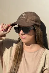 Gorra tipo baseball de cuero color negro, con bordado frontal que incluye un símbolo de flor de lis y la inscripción 'EST. 1994'.