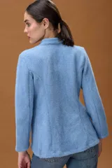 Blazer de tejido suave con acabado ligeramente afelpado, en color celeste. Presenta un diseño minimalista de corte entallado, cuello elevado y cierre frontal oculto.