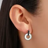 Aros colgantes plateados con forma circular y detalle de nácar blanco.