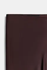 Falda midi de corte recto confeccionada en tejido satinado con acabado brillante, tiro alto y cintura elástica.