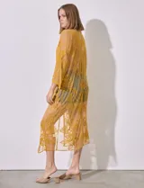 Kaftan largo color amarillo mostaza, de micro tul bordado con motivos florales. Tiene mangas largas y cordón ajustable en la cintura.