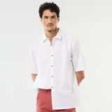 Camisa de manga corta de lino color blanco, con cuello camisero y cierre frontal de botones.
