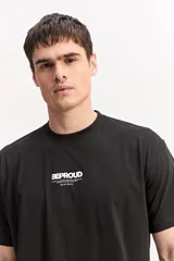 Remera oversize de algodón color negro, con diseño amplio y estampa en la espalda que incluye texto en relieve y gráficos.