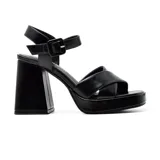 Sandalias negras de cuero sintético con plataforma y taco cuadrado alto. Tiras anchas cruzadas sobre el empeine y pulsera con hebilla al tobillo.