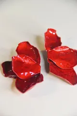 Par de caravanas (aretes) de gran tamaño, con forma de pétalos de rosa en color rojo brillante y acabado lacado.