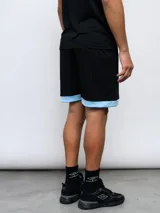 Short deportivo Umbro azul marino con cintura elástica y ribete blanco en el ruedo.