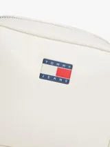 Cartera tipo bandolera de Tommy Jeans, color blanco con acabado brillante. Presenta cierre de cremallera, correa ajustable y la insignia distintiva de la marca en la parte frontal.
