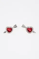 Caravanas de metal plateado con diseño de corazón rojo esmaltado, rodeado de cristales brillantes y atravesado por una flecha.