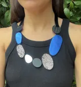 Collar artesanal con piedras de cuero en colores azul, negro, plateado y gris.